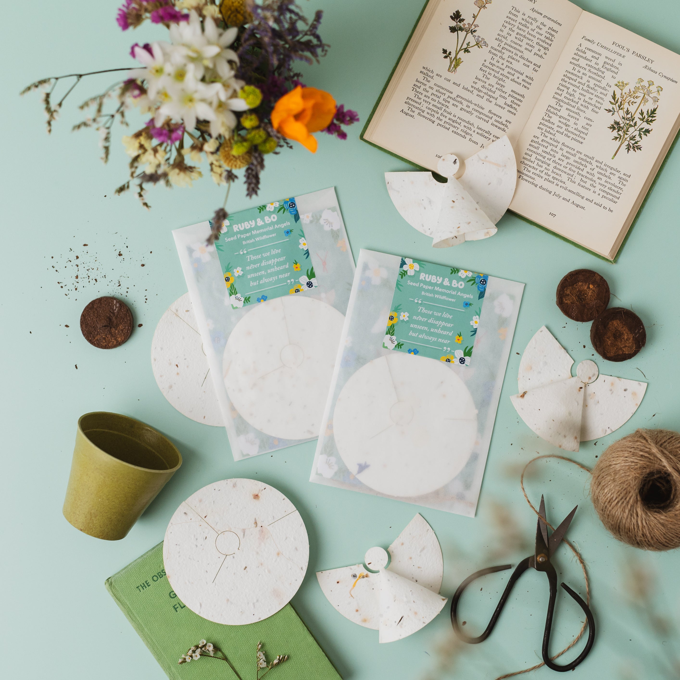 Two packs of Ruby & Bo plantable paper angels on a mint green background