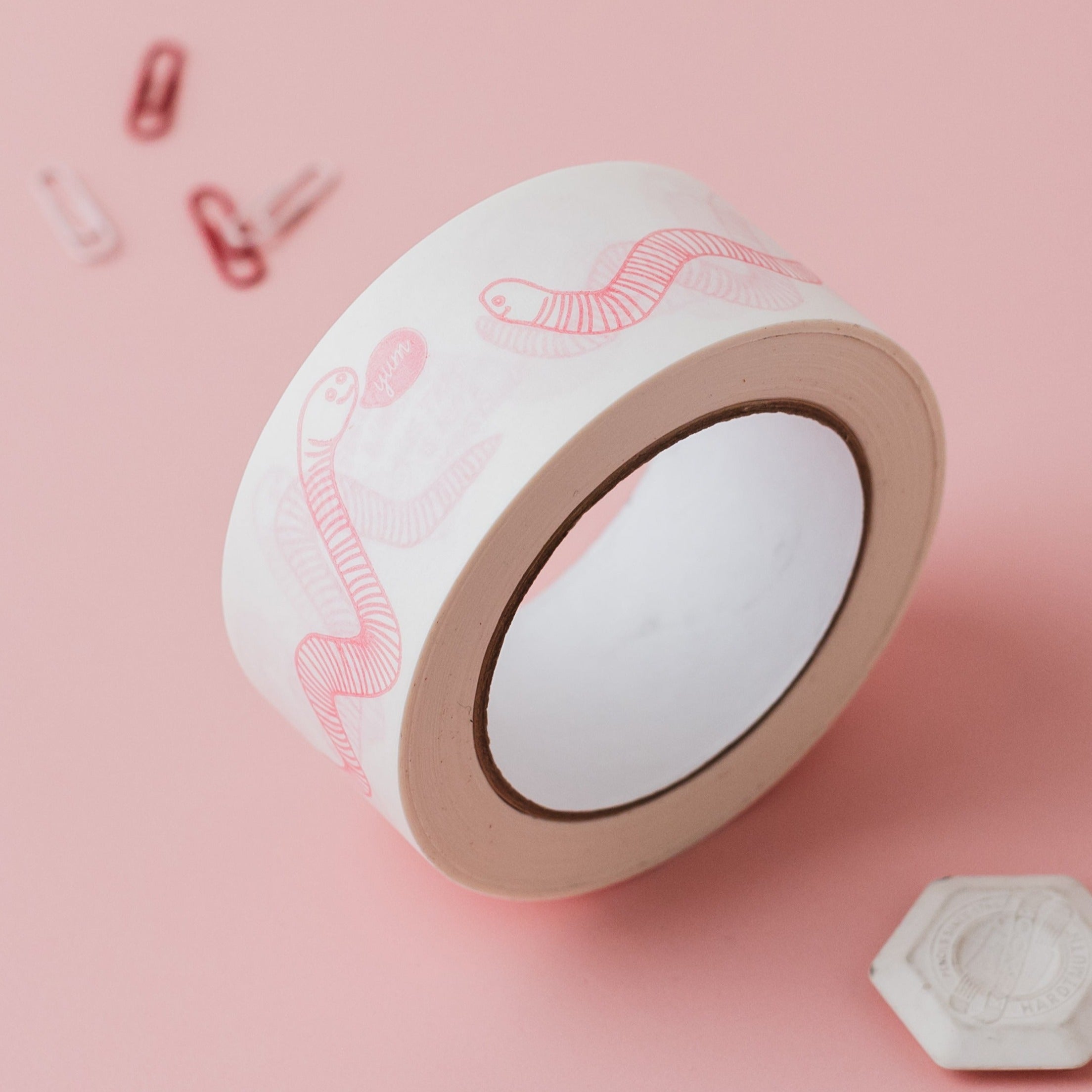 Feed the worms paper tape on pale pink background