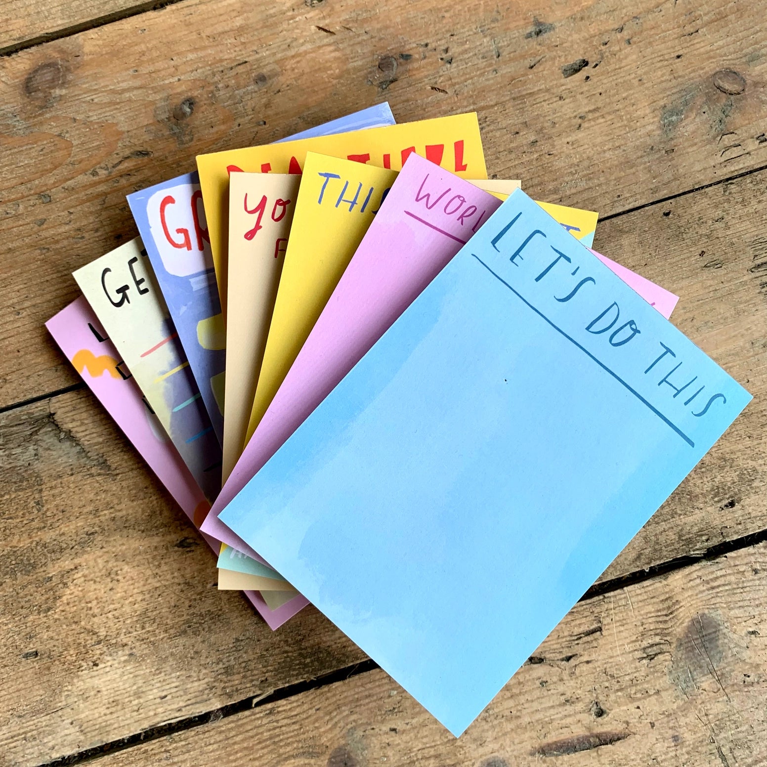 Stack of colorful notepads on a wooden surface