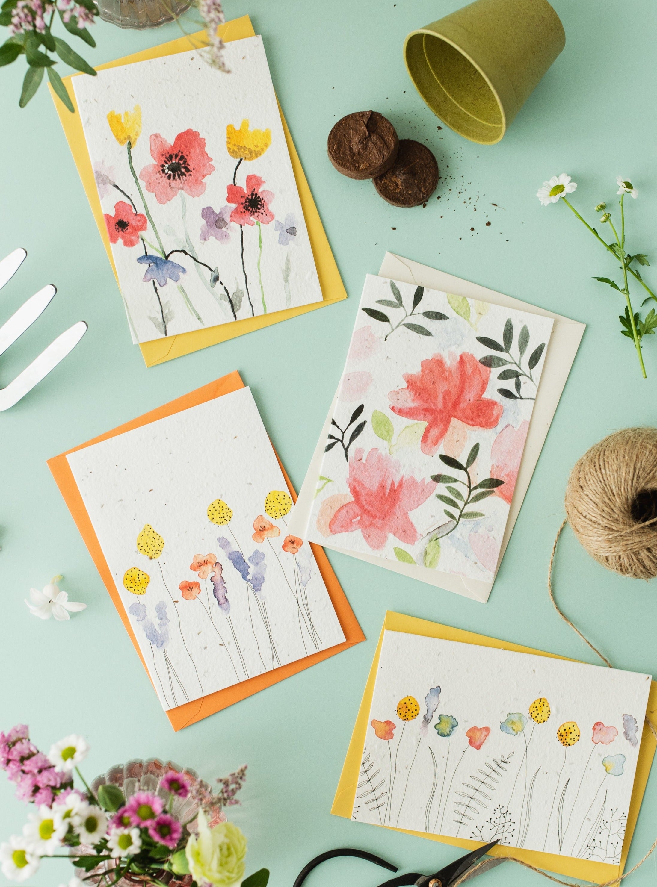 a selection of ruby and bo plantable cards on a green background