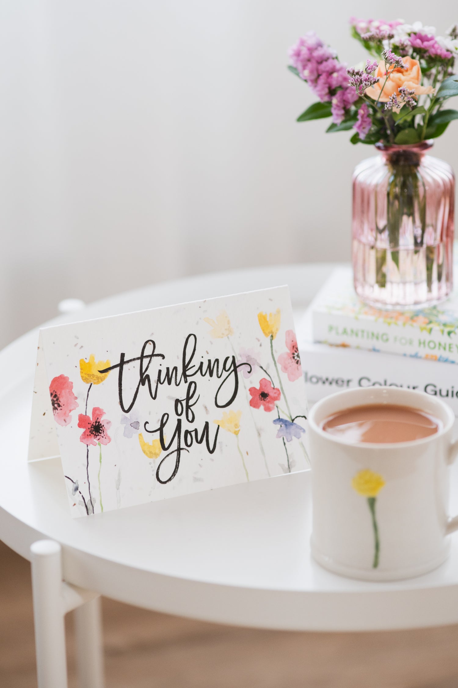 Ruby &amp; Bo plantable sympathy card on a table top next to a mug of tea and a pink vase of wildflowers