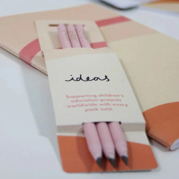 Close up of three recycled pencils in cardboard sleeve packaging