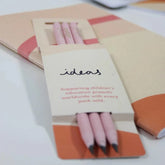 Close up of three recycled pencils in cardboard sleeve packaging