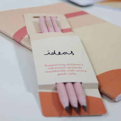 Close up of three recycled pencils in cardboard sleeve packaging
