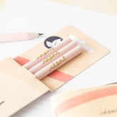 Close up of three light pink recycled pencils showing gold foil inscription on exterior