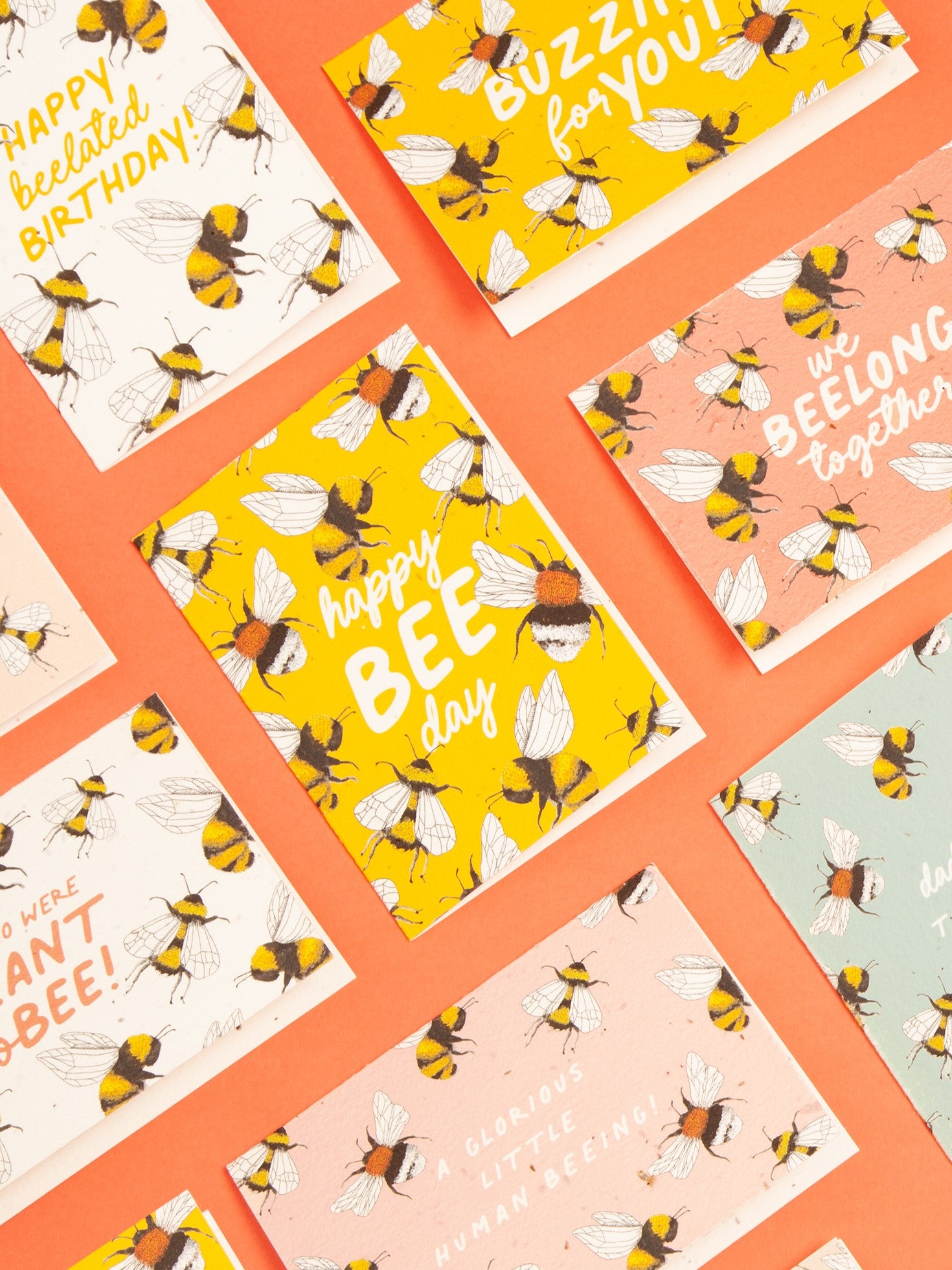 happy bee day plantable birthday card on coral background surrounded by other plantable cards